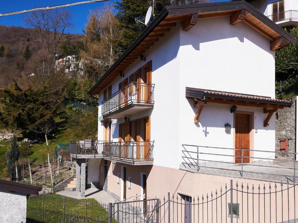 a white building with balconies and a fence at Holiday Home Casa del Sole by Interhome in Casasco Intelvi