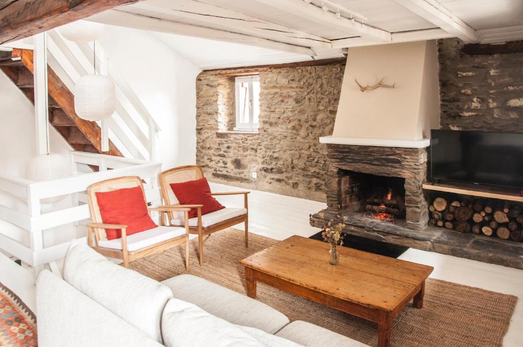 a living room with a couch and a fireplace at CASA TON, junto a Baqueira y Aigüestortes in Sorpe