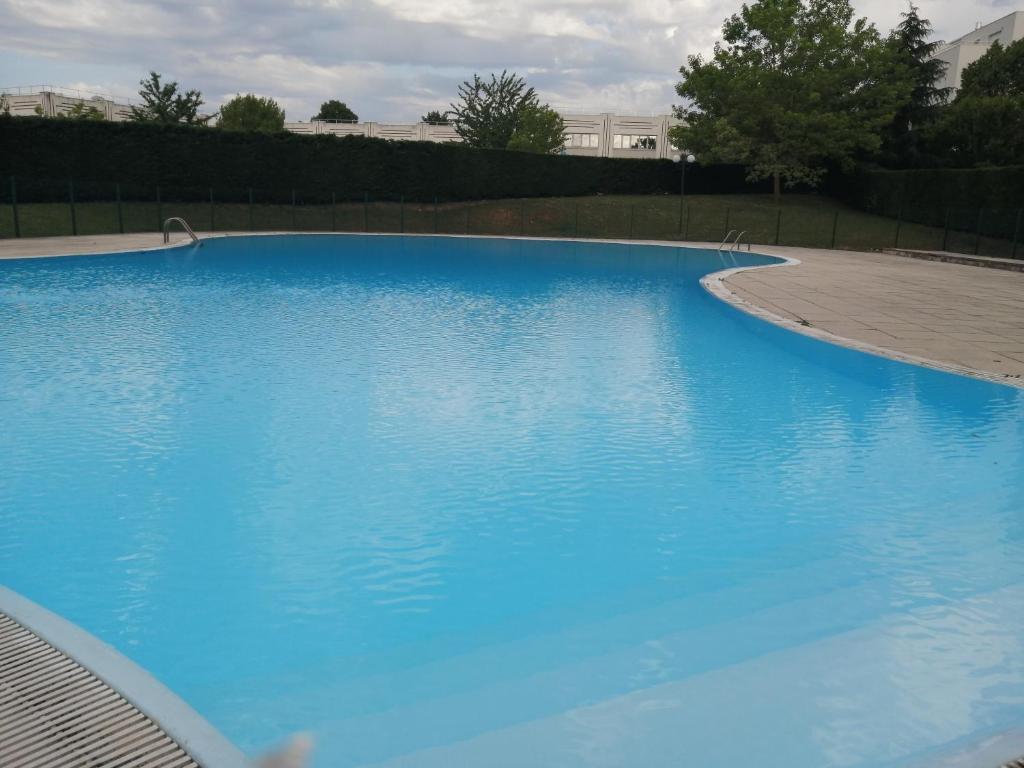 une grande piscine d'eau bleue dans l'établissement Romantisme et glamour avec spa, piscine et jardin, à Dijon