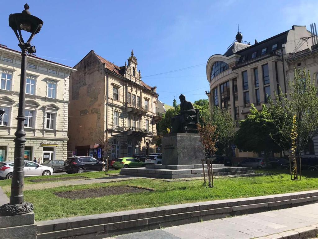 a statue in the middle of a city with buildings at Apartments on Shevchenko avenue in Lviv