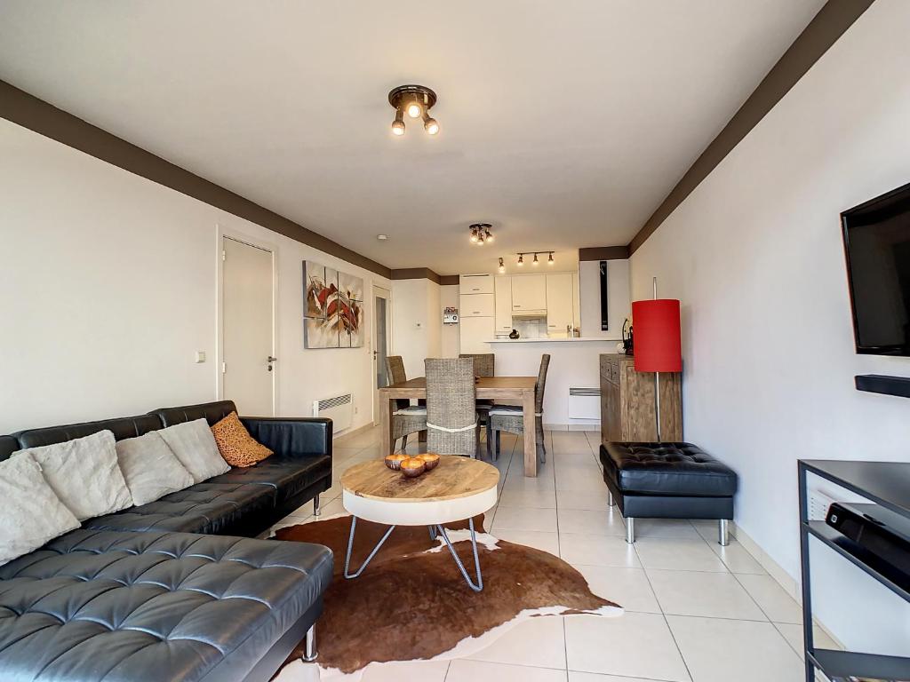 een woonkamer met een bank en een tafel bij Appartement 'Plaza' te Oostduinkerke - Bad in Oostduinkerke-Bad