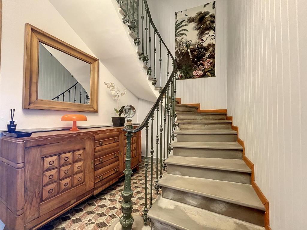 a staircase in a house with a mirror on the wall at L&#39;Oiseau Bleu ROLLIER in Roubia