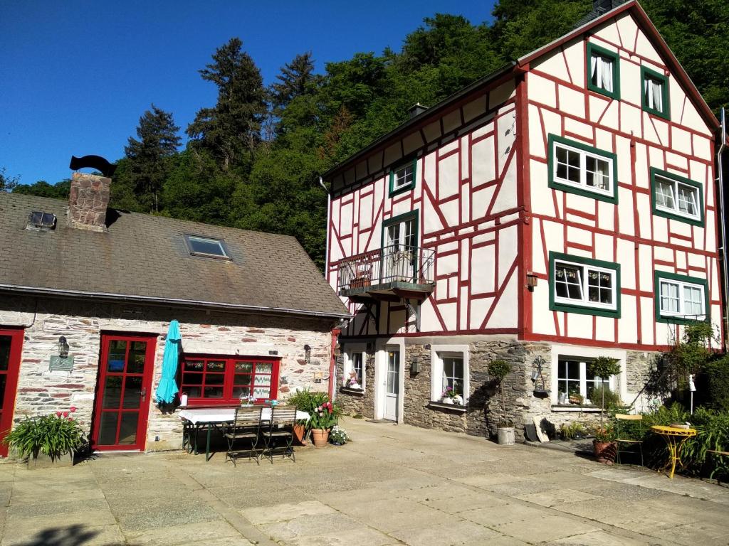 un edificio rojo y blanco con un patio en la parte delantera en Ferienhaus Barbarasegen, en Altlay