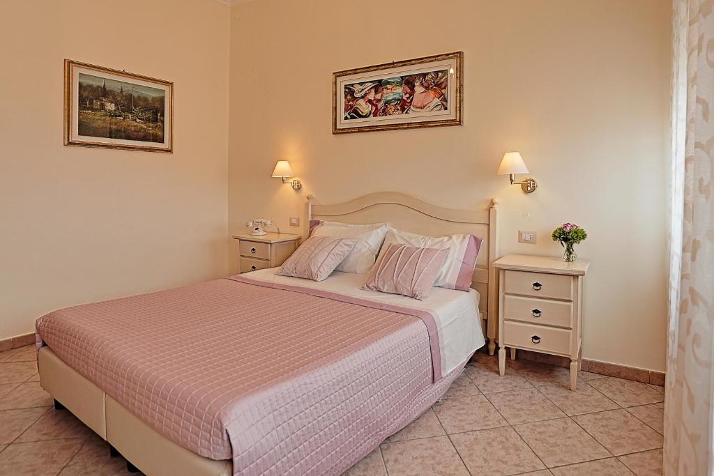 Un dormitorio con una cama y dos mesitas de noche. en il Castello Guest House, en Sassari