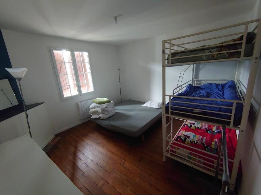 a room with two bunk beds and a bed at Maison entre Plages et Forêts in Lévignacq