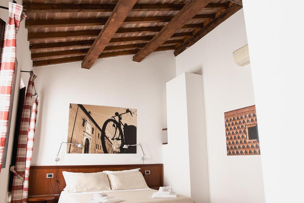 sypialnia z łóżkiem i rowerem na ścianie w obiekcie Boutique Rooms 3 0 w mieście Ferrara