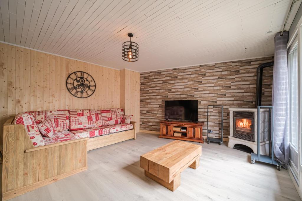- un salon avec une cheminée, un canapé et une table dans l'établissement Le Loft, à Ornans