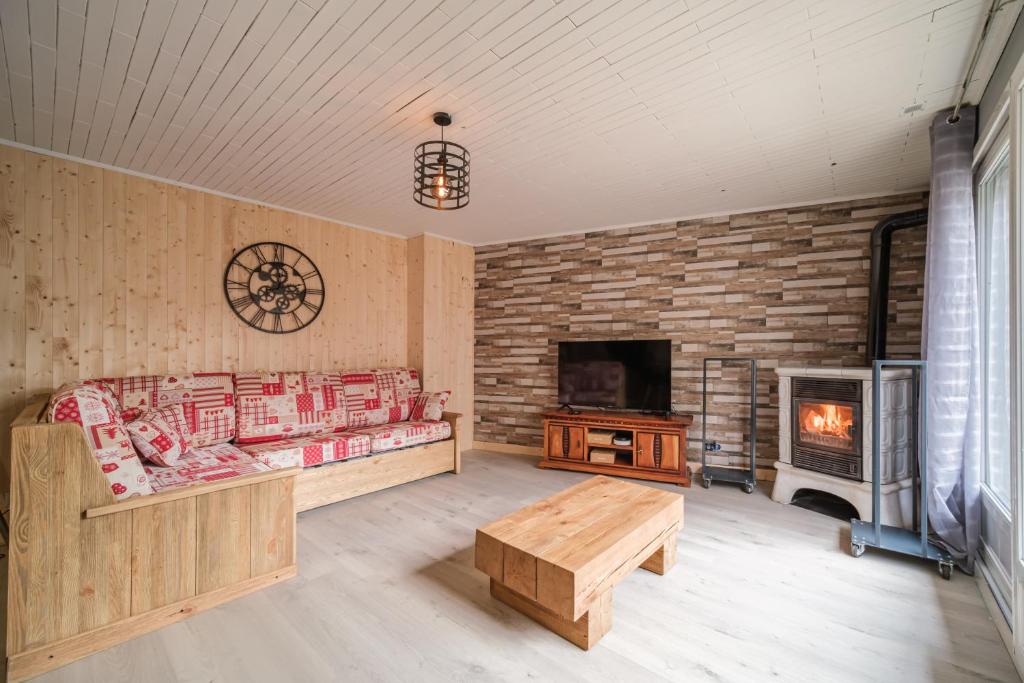 a living room with a fireplace and a couch and a table at Le Loft in Ornans