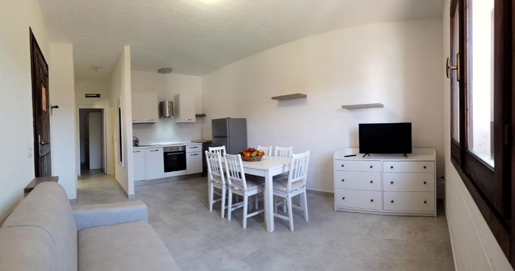 cocina y comedor con mesa y sillas en Moderno e ampio trilocale, en Porto Pozzo