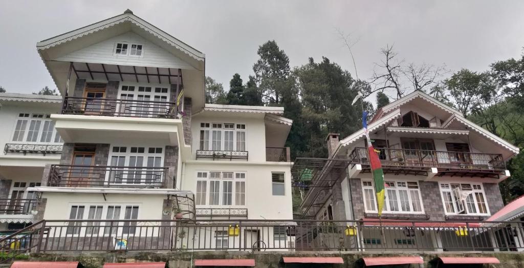 a large white building with a flag in front of it at Sherpa Villa in Gangtok