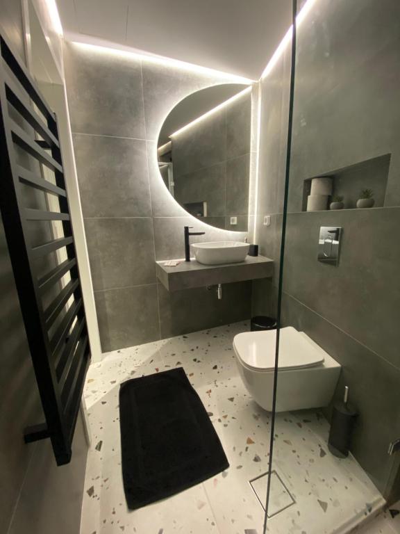 a bathroom with a toilet and a sink and a mirror at Modern Living in Markopoulo center in Markopoulo