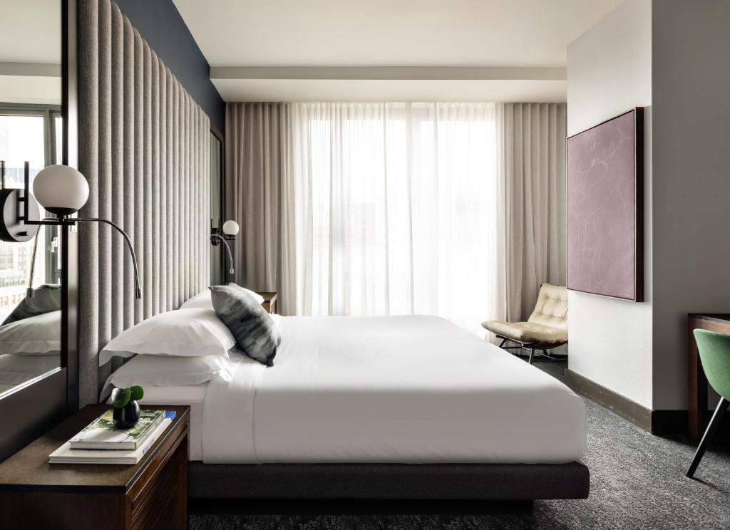 um quarto com uma grande cama branca e uma janela em Kimpton Hotel Eventi, an IHG Hotel em Nova York