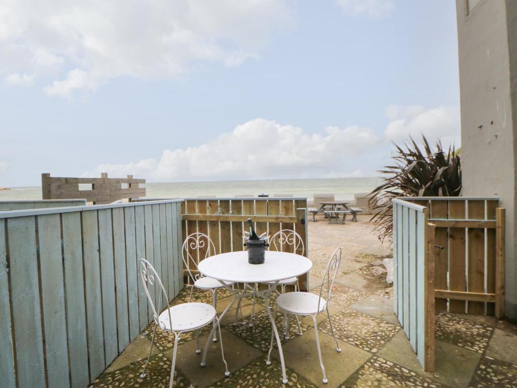 een tafel en stoelen op een balkon met uitzicht op het strand bij The Look Out in South Shields