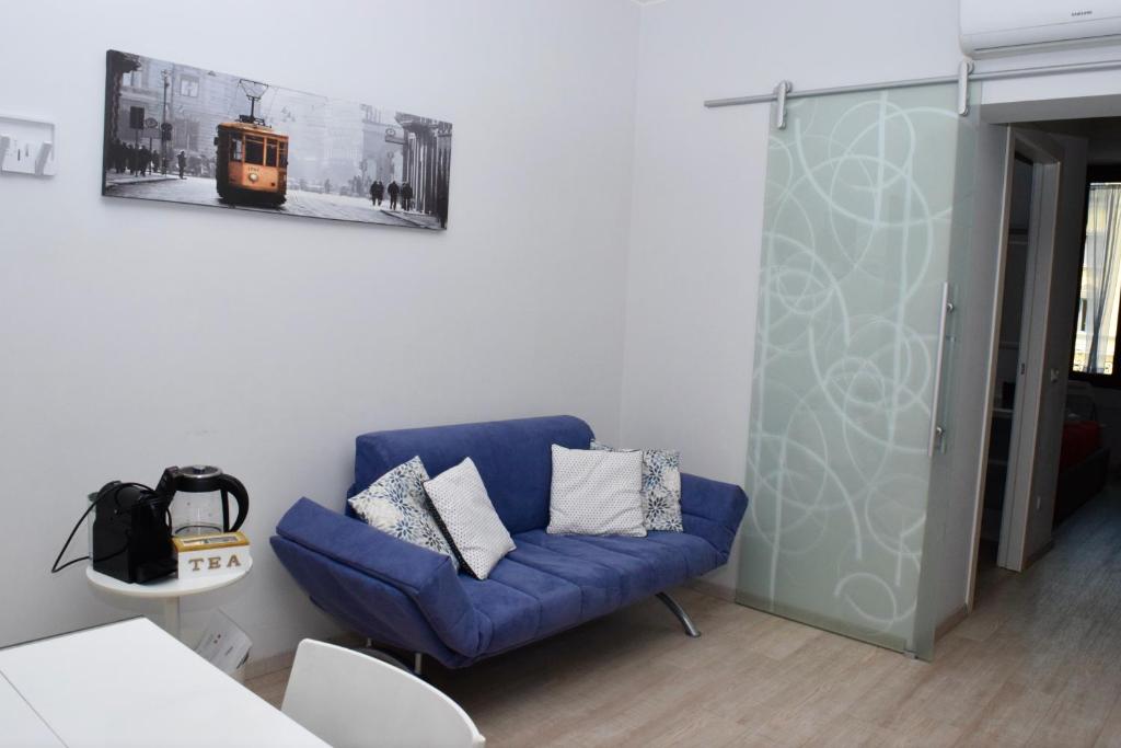 un sofá azul en una sala de estar con una foto en la pared en NEW! TUTTO QUI - APT WAGNER - CITY LIFE (cir01686) en Milán