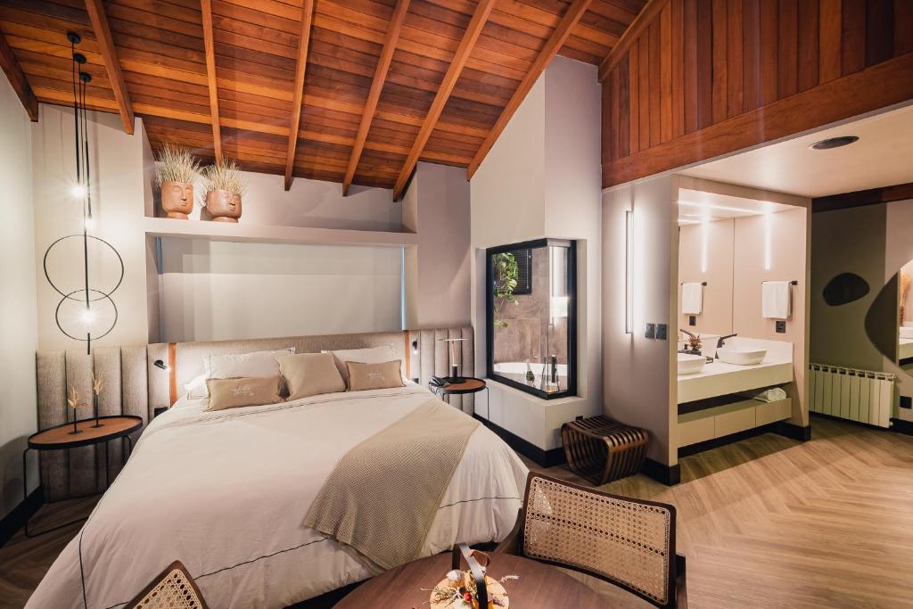een slaapkamer met een groot bed en een badkamer bij Pousada Bella Terra in Gramado