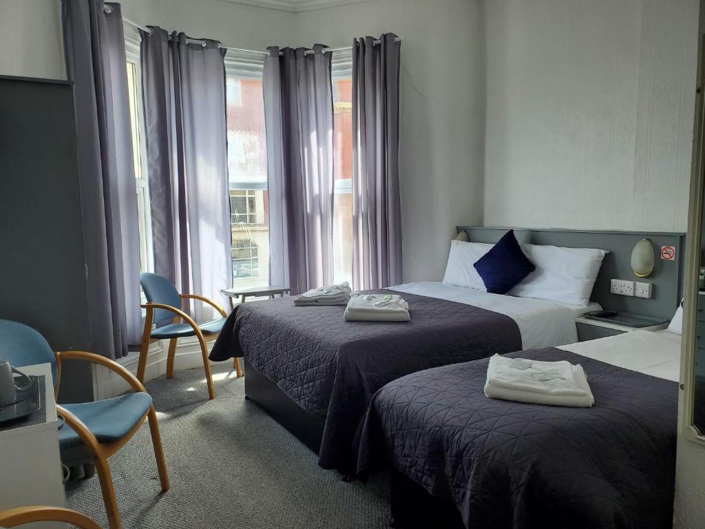 a hotel room with two beds and a window at Brooklyn Hotel in Blackpool