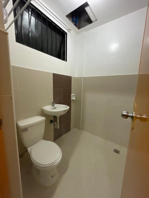 La salle de bains est pourvue de toilettes et d'un lavabo. dans l'établissement Sto. Niño Residences Standard Room, à Lucena