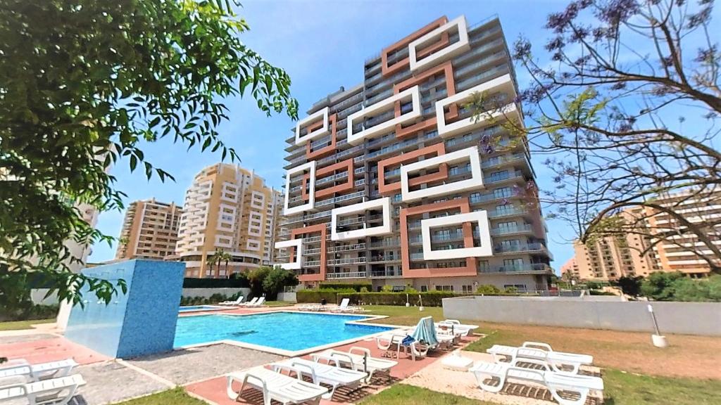 un edificio con piscina al lado de un edificio en Apartamentos Turisticos Rocha Tower 13C, en Portimão