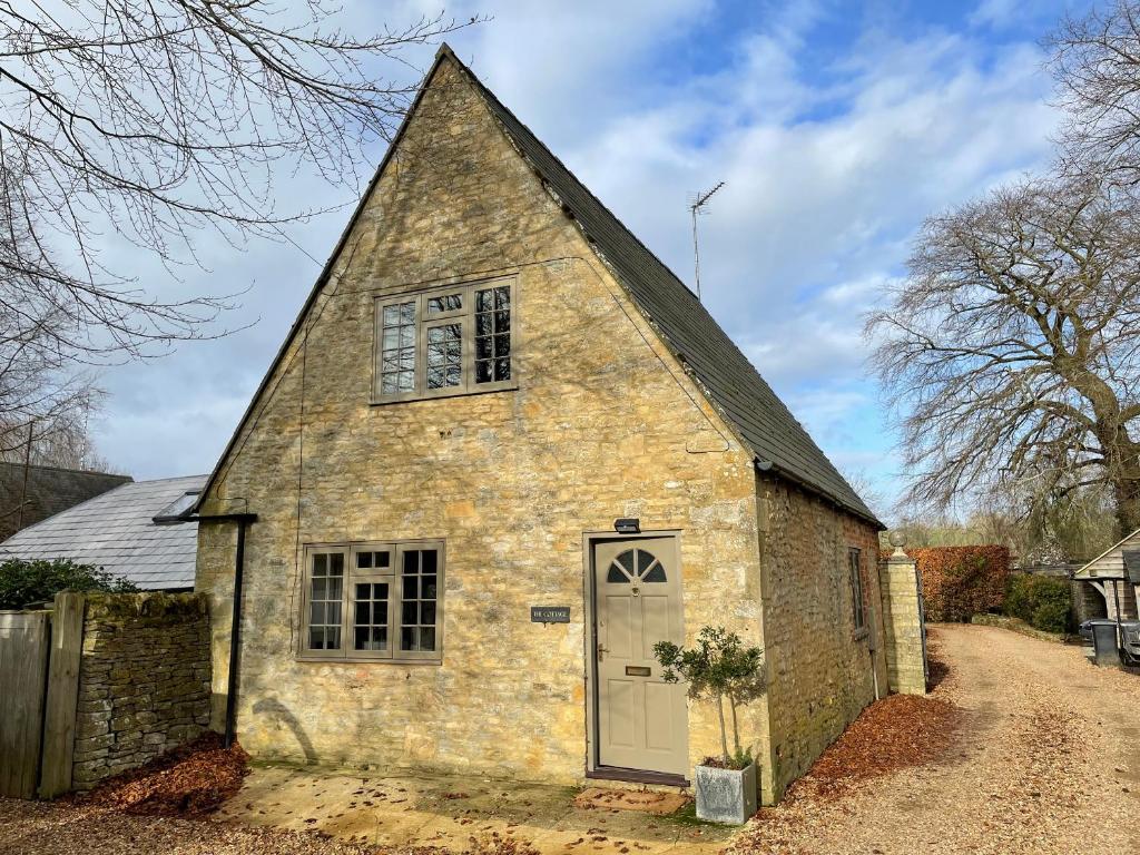 an old stone church with a white door at Oma's Cottage in Moreton in Marsh