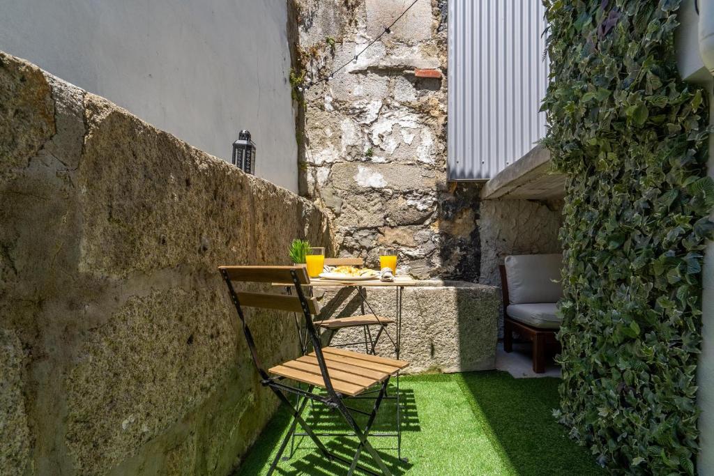 a wooden chair sitting next to a table in a courtyard at Enchanting Unique Flat - Ace Location in Porto