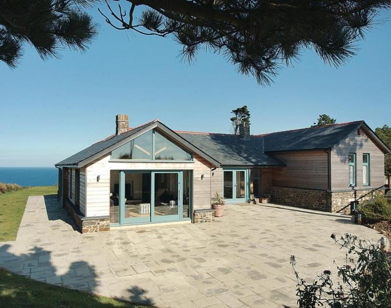 a house with a large patio in front of it at Ossco in Polzeath