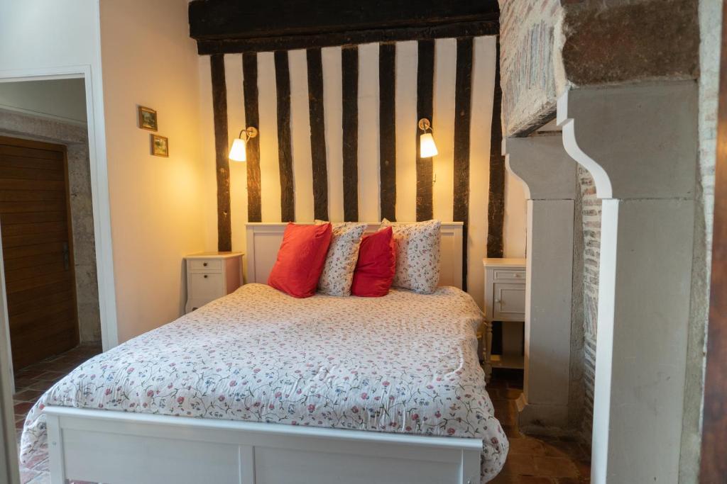 um quarto com uma cama com almofadas vermelhas em Appartement Meneau em Charité-sur-Loire