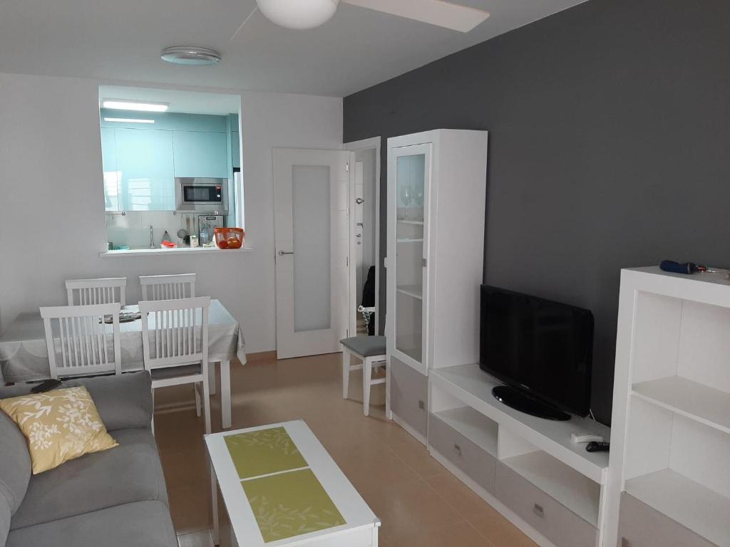 a living room with a couch and a tv at Apartamento Alegria in Garrucha