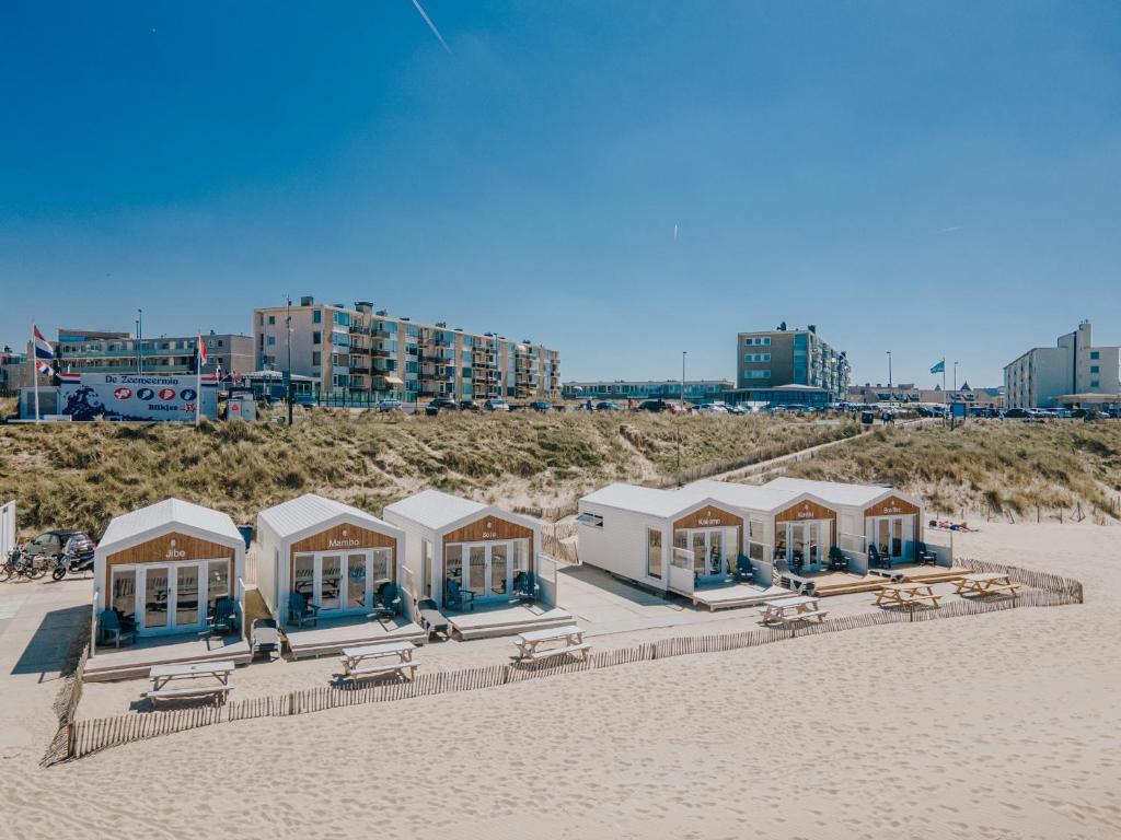 una fila de cabañas de playa en una playa de arena en BUDDHA BEACH BUNGALOWS Adults Only, en Zandvoort