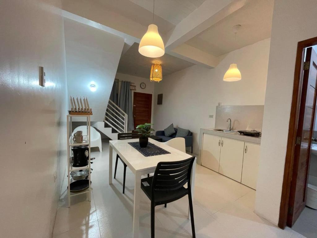 uma cozinha e sala de jantar com mesa e cadeiras em Sto. Niño Whole House w/ 2 AC Bedrooms em Lucena