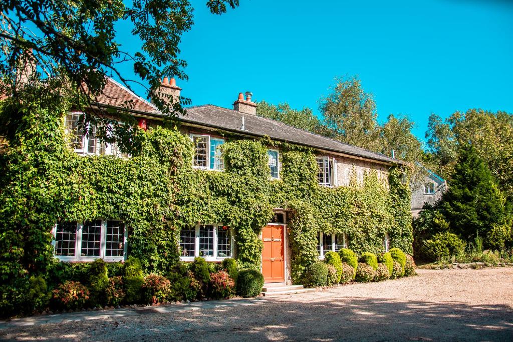 an ivy covered house with a red door at The Old Mill in Lymington