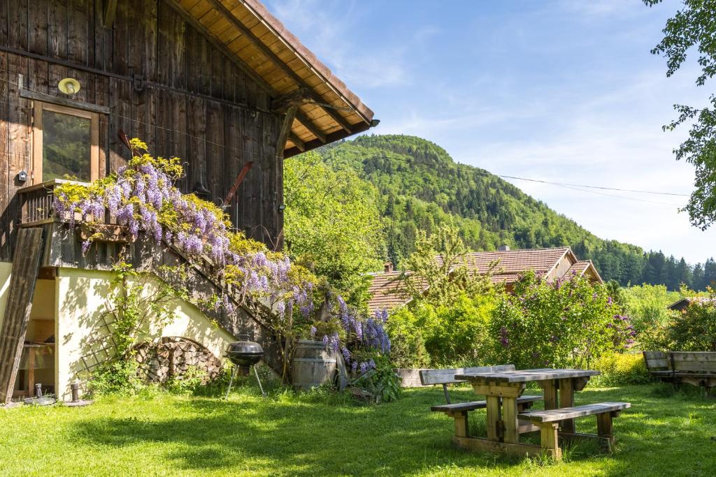 ein Haus mit einem Picknicktisch und lila Blumen darauf in der Unterkunft Chalet d'en Ô in Les Clefs