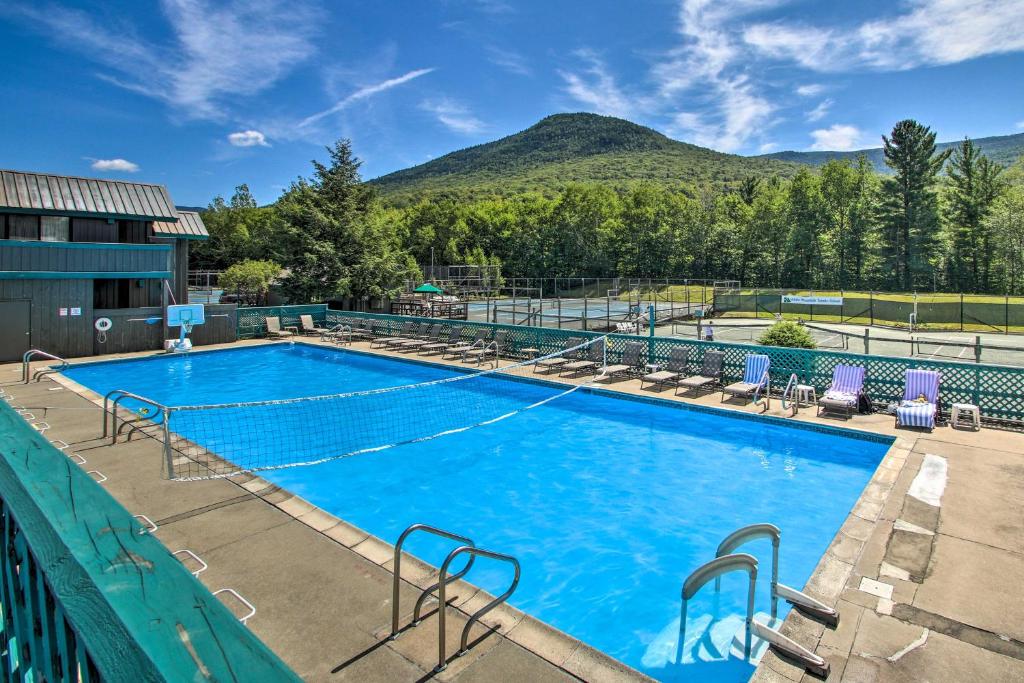 a large swimming pool with mountains in the background at Loon Mountain Townhome with Pool and Slope Views! in Lincoln