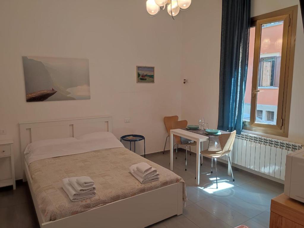 a bedroom with a bed and a table and a window at Dormi Tranquillo in Bologna