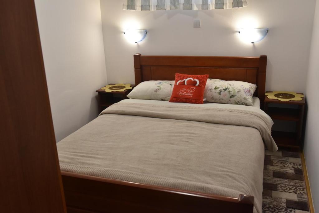 a bedroom with a bed with a red pillow on it at Apartment VUK in Žabljak