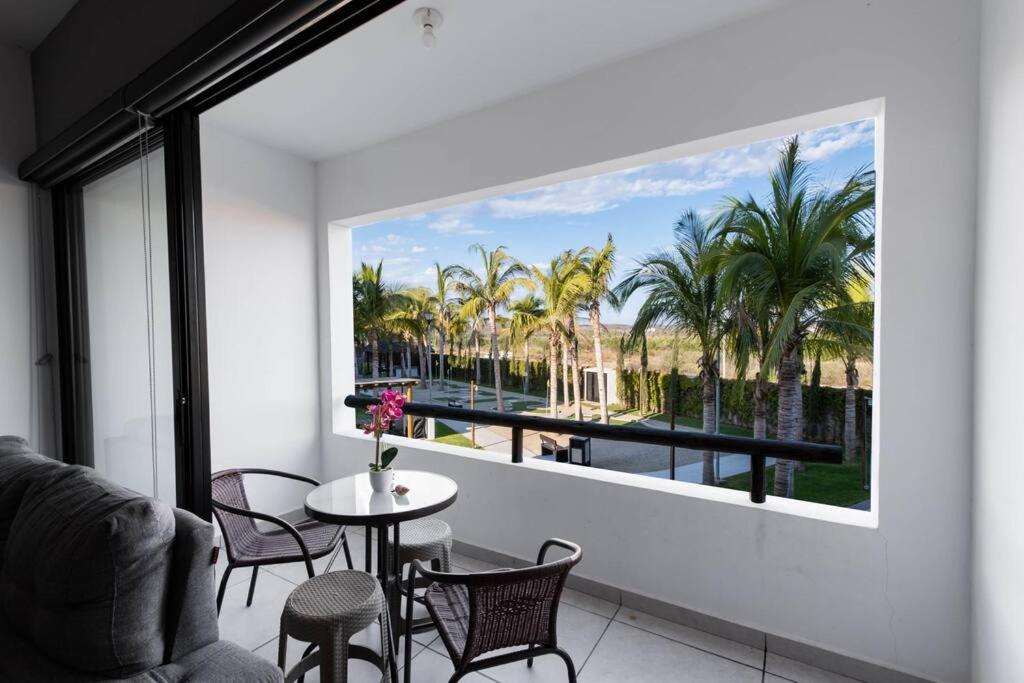 Departamento Joya ideal para tus vacaciones ! في مازاتلان: غرفة مع نافذة كبيرة مع طاولة وكراسي