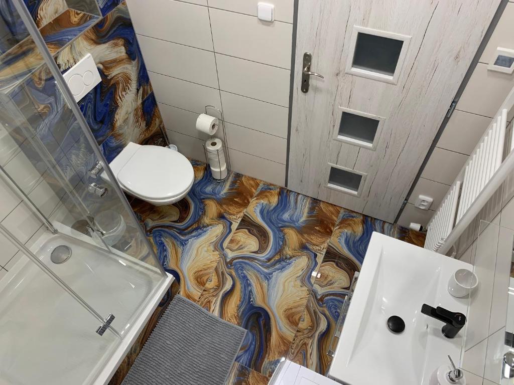 a bathroom with a toilet and a shower and a sink at Apartmány Žižkova in Česká Lípa