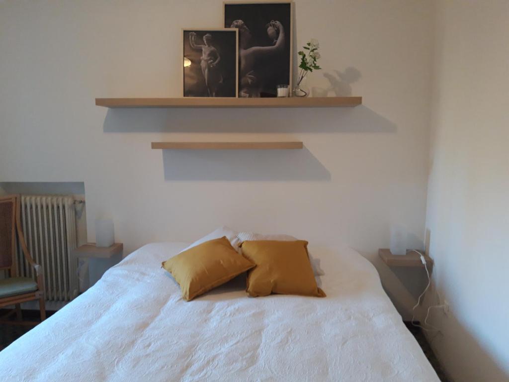 Moriago della BattagliaにあるLocanda Torontoの白いベッド(黄色い枕2つ付)