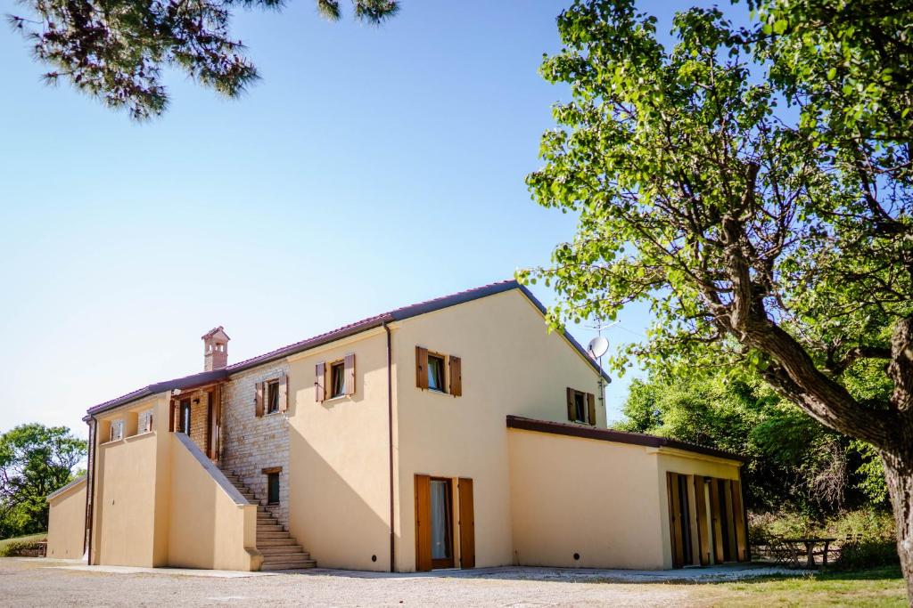 a building with a tree in front of it at Agriturismo Conero in Ancona