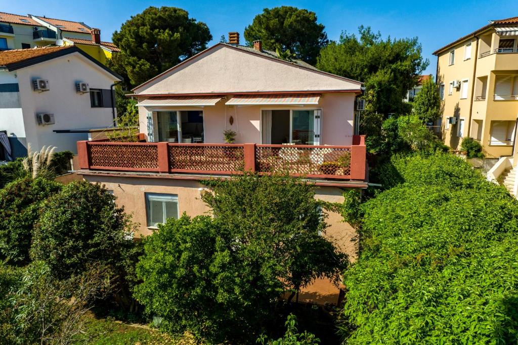 dom z balkonem na szczycie krzaków w obiekcie Apartment Axelle 50 METERS TO THE BEACH w mieście Banjole
