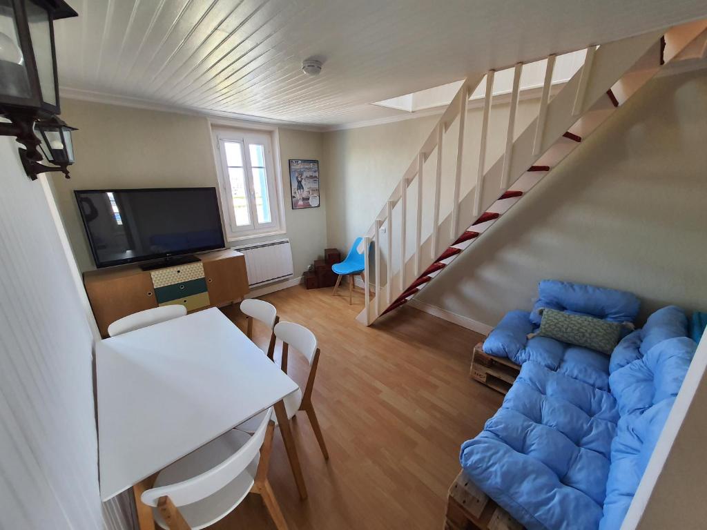 sala de estar con sofá azul y escalera en Duplex cosy à quelques minutes à pied de la mer., en Mers-les-Bains
