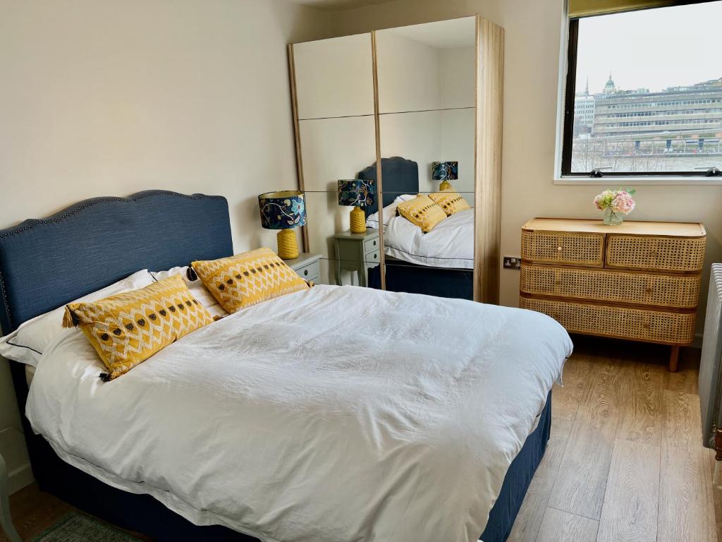 a bedroom with a large bed and a large window at Thames Bankside River View City Apartment in London