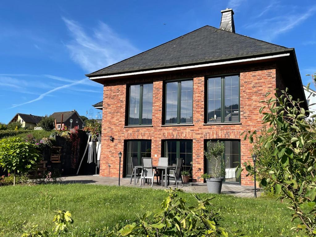 a red brick house with a table and chairs at Ferienwohnung Probst in Ellenz-Poltersdorf
