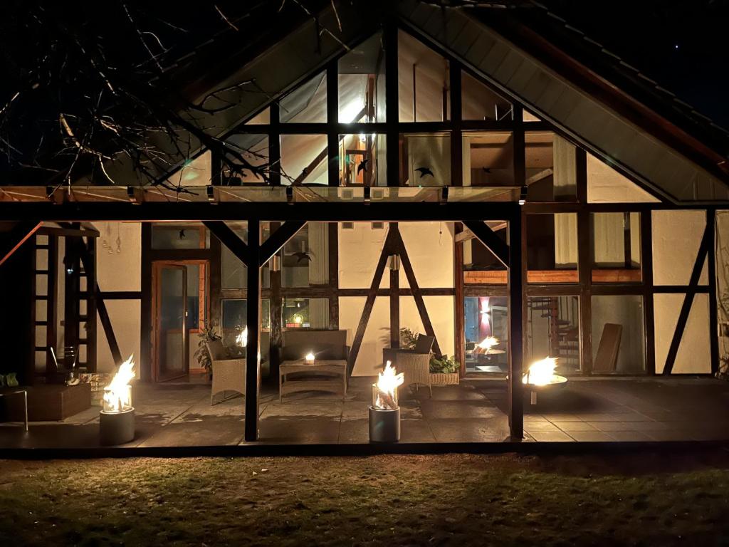a house lit up at night with candles in front at Traumscheune mit Pool, Kamin und privatem Spa in Linnich