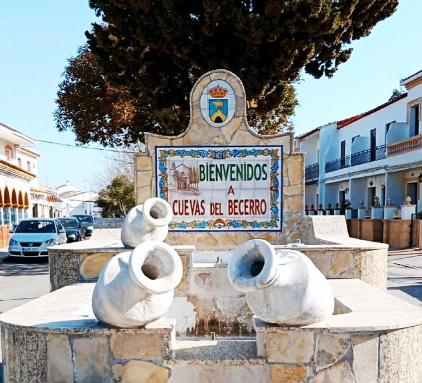 um monumento em frente a uma placa numa rua em Casa Blanca em Cuevas del Becerro