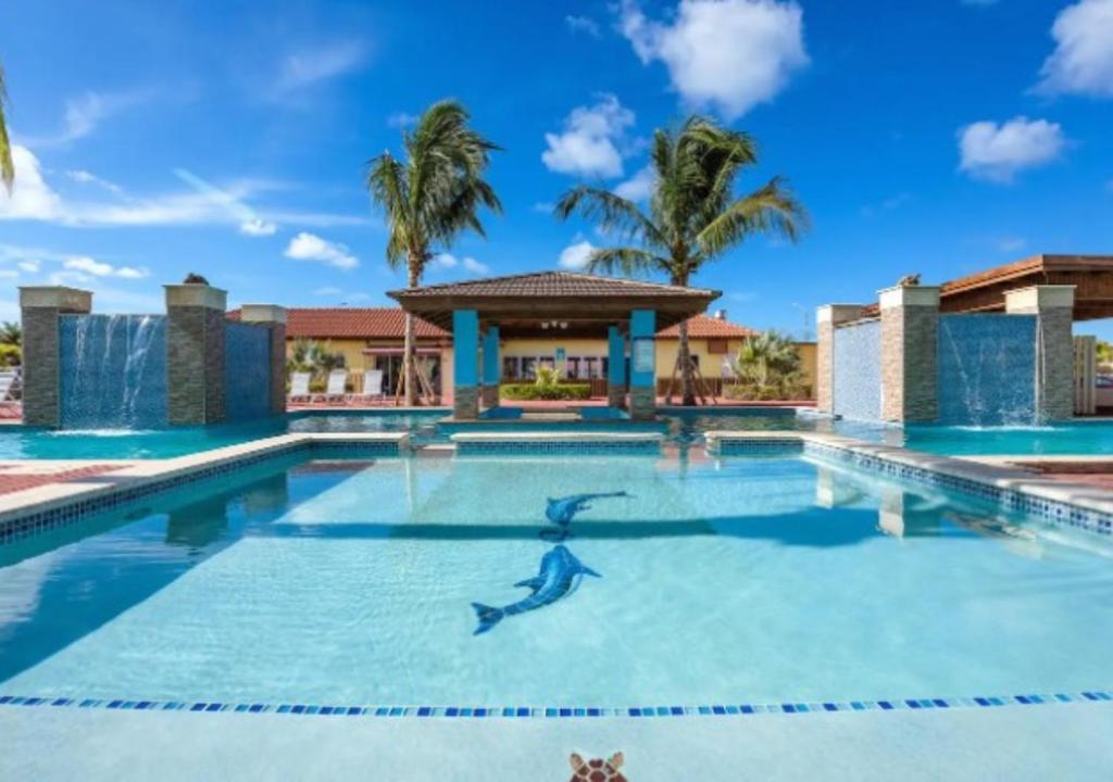 - une piscine avec une personne dans l'eau dans l'établissement Apartamento Vacacional en Aruba Cerca a la Playa, à Palm-Eagle Beach