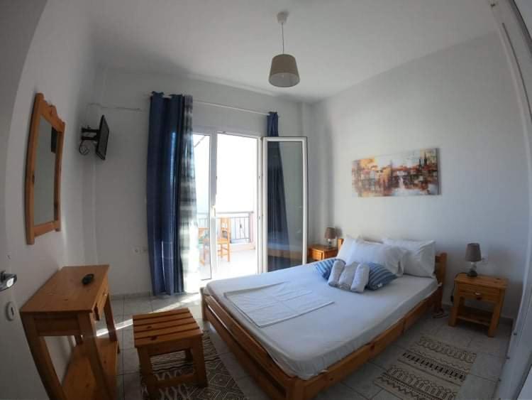 a bedroom with a bed and a large window at MAGDALINOS APARTMENTS (3) in Nea Skioni