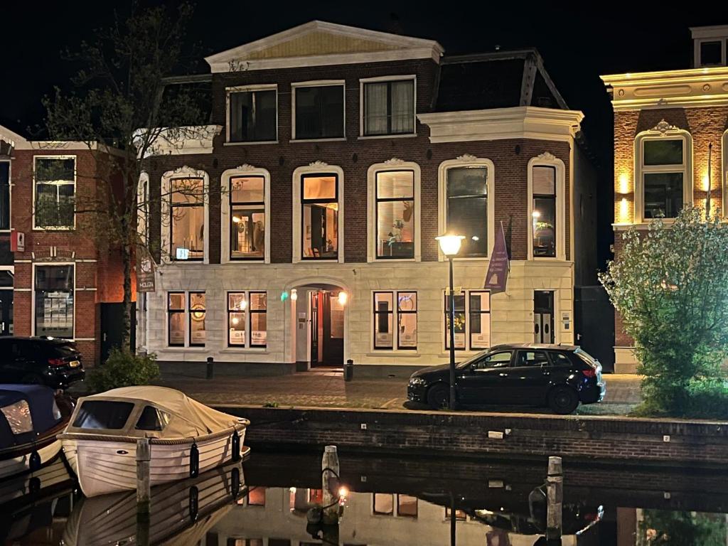 una casa con un barco estacionado frente a ella en Stadslogement Westersingel, en Sneek