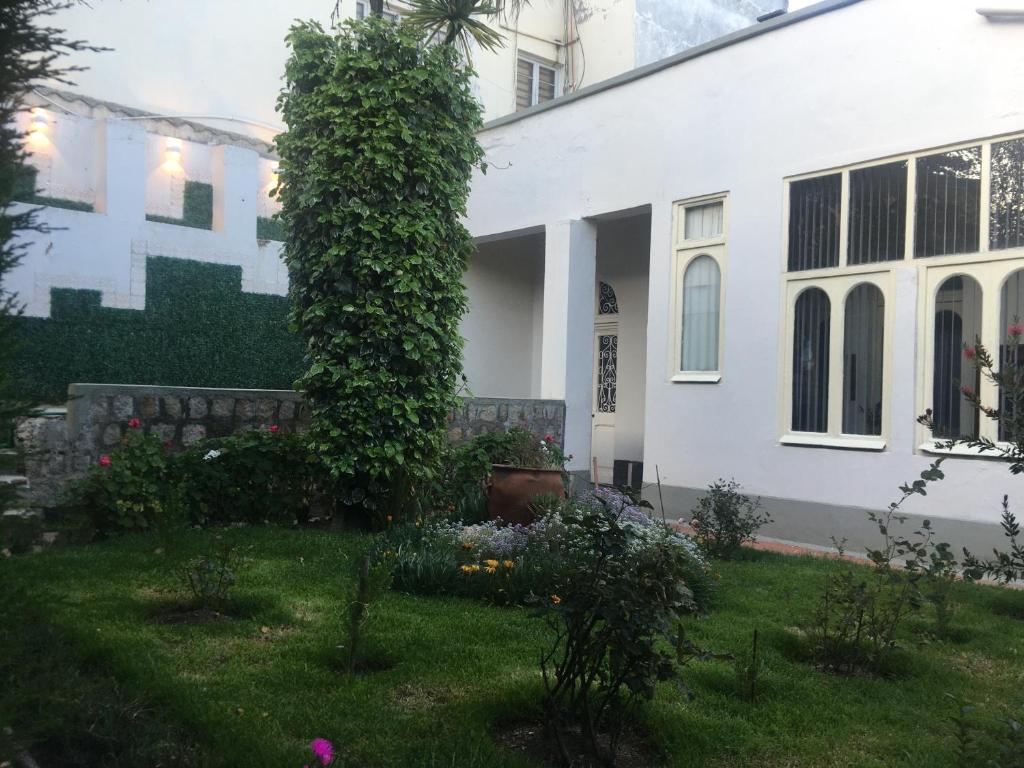 una casa blanca con un jardín delante en La casa de Teresita, en La Paz