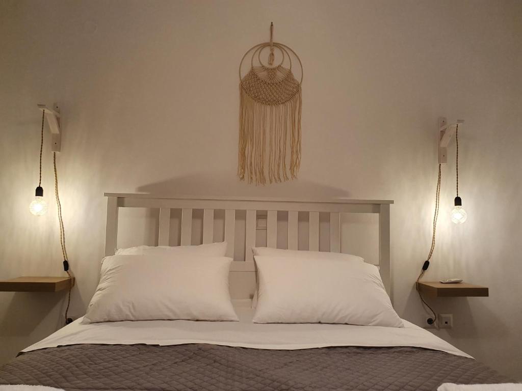a bedroom with a bed with two pillows and two lights at Kalavarda Cosy Home 2 in Kalavárda
