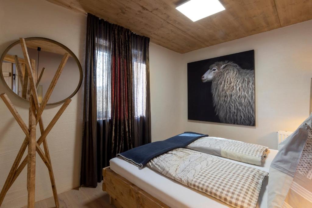 ein Schlafzimmer mit einem Bett und einem Bild eines Schafs in der Unterkunft Appartementhaus Anka in Seefeld in Tirol